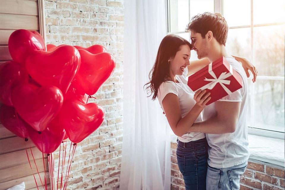 couple-cuddling-next-to-heart-shaped-balloons