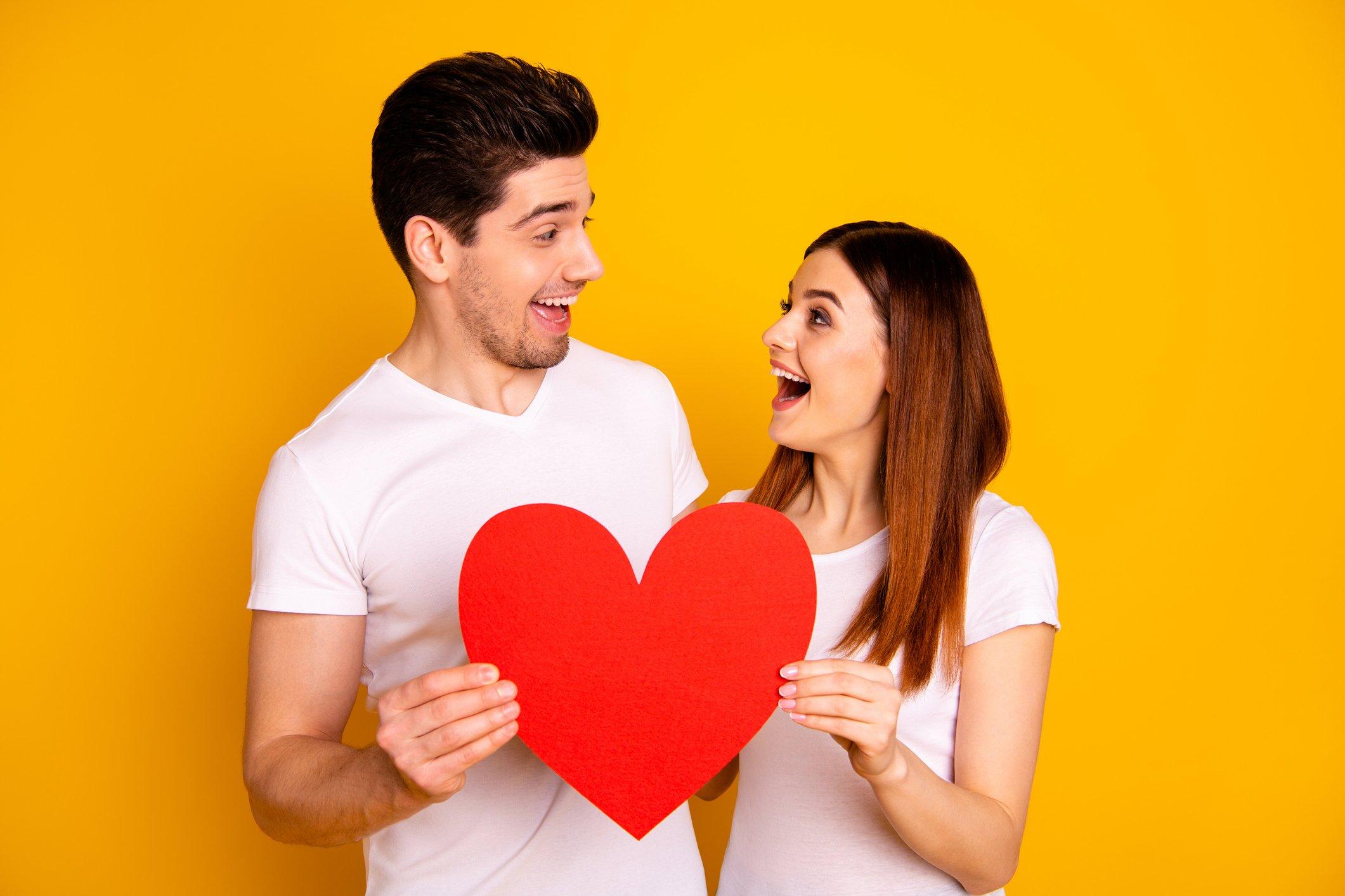 couple-smiling-at-eachother-with-heart-cutout