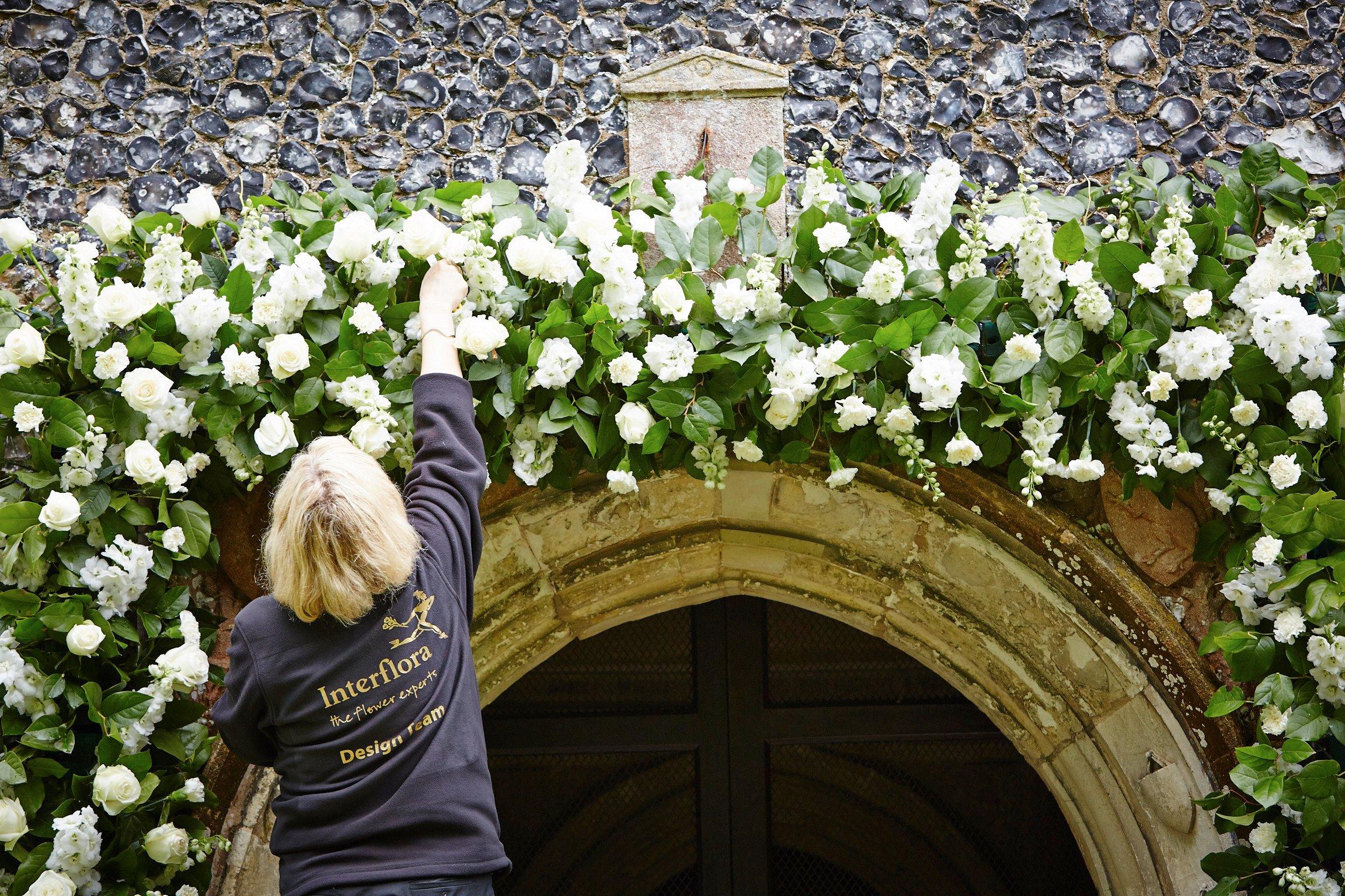 florist-creating-arch-of-flowers-wedding