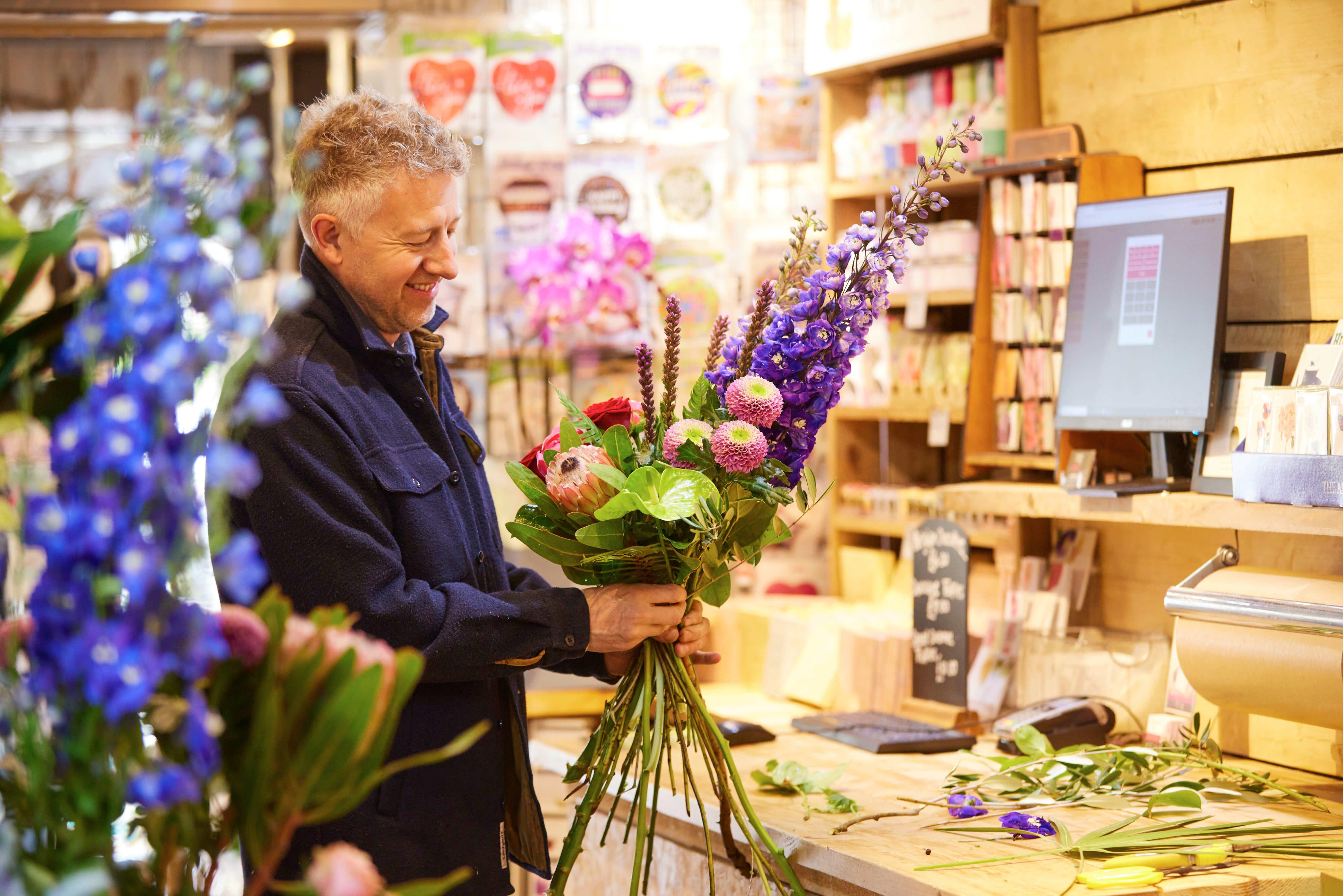 local-florist-arranging-flower-bouquet-purple-home