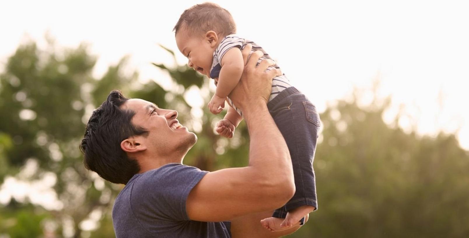 new-dad-with-baby-outdoors-playing