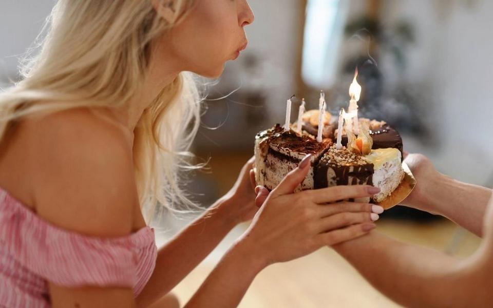person-blowing-out-candles-on-cake